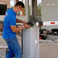 Teknisi melakukan setting palang parkir otomatis